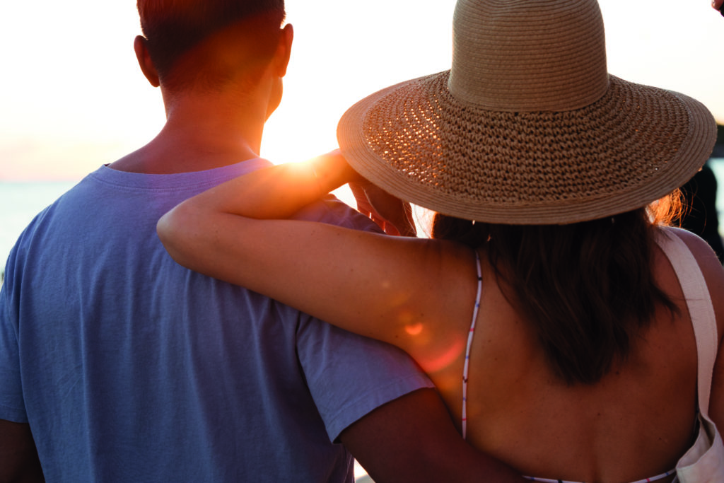 Couple watches the sunset from Ala Moana Beach Park