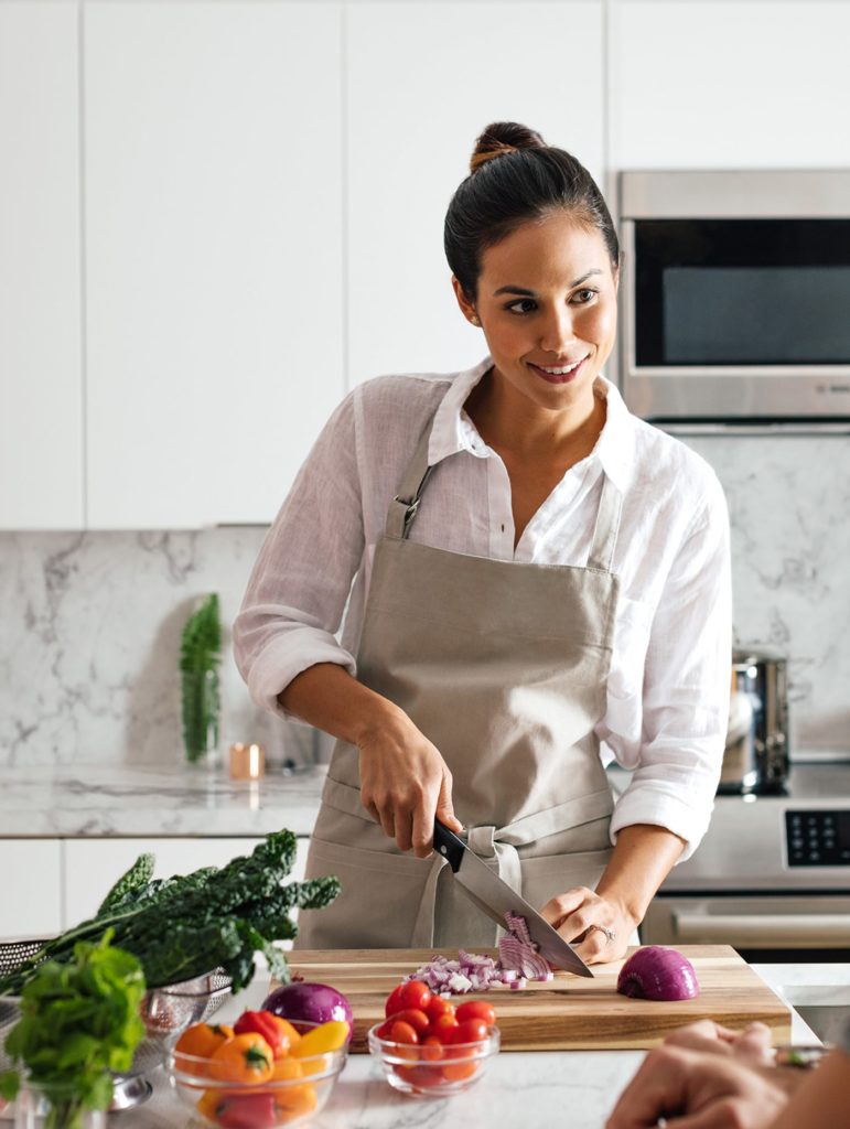 Young woman preparing food in her 'A'ali'i condo's kitchen